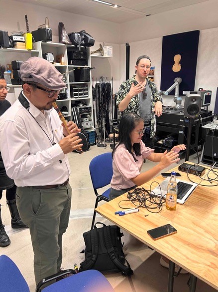 Dr. Marzelan Saleh presenting SEA wind instruments, Roan Opiso and Tim-Tarek Grund working with gesture control software for live-electronics in the acoustics laboratory at mdw in Vienna. 